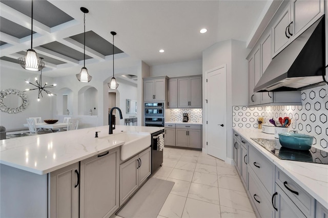 kitchen featuring marble finish floor, black appliances, under cabinet range hood, and gray cabinetry