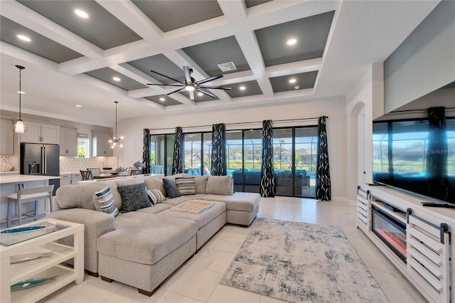 living area featuring ceiling fan with notable chandelier, coffered ceiling, beam ceiling, and recessed lighting