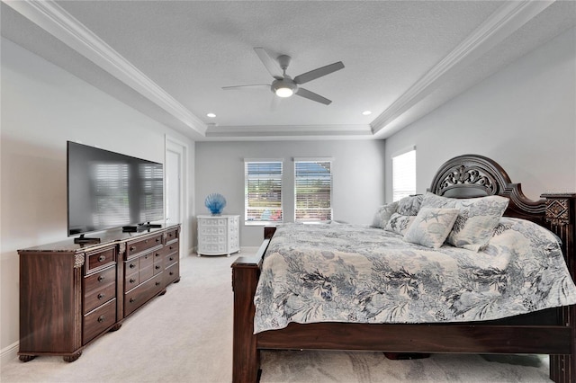 bedroom with baseboards, light colored carpet, a tray ceiling, a textured ceiling, and crown molding