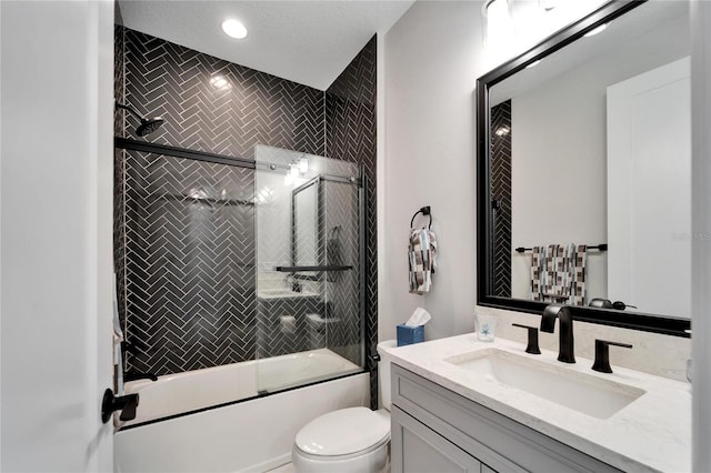 full bath featuring toilet, shower / bath combination with glass door, and vanity