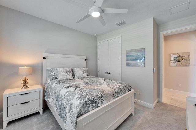 bedroom with light carpet, a closet, visible vents, and baseboards