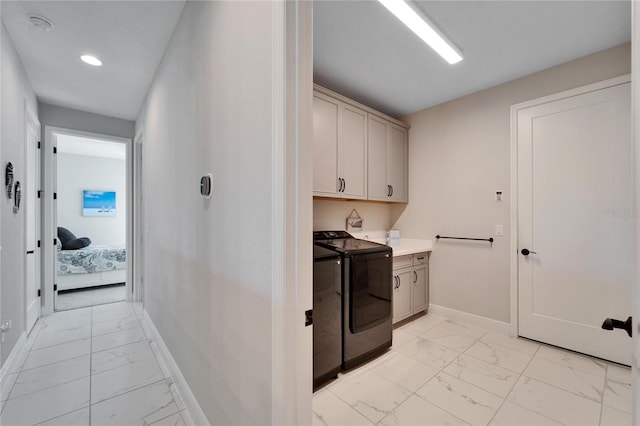 laundry area with marble finish floor, washer and clothes dryer, cabinet space, and baseboards