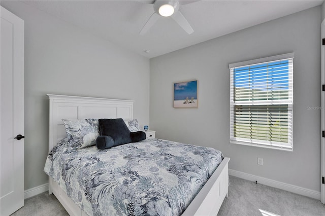 bedroom featuring light carpet, a ceiling fan, and baseboards