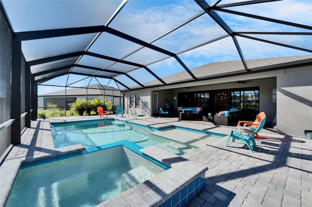 view of swimming pool with a patio, a pool with connected hot tub, glass enclosure, ceiling fan, and an outdoor living space