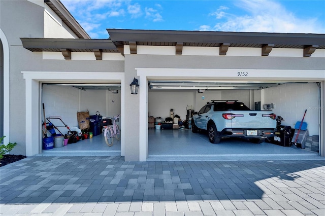 view of parking with a garage and decorative driveway