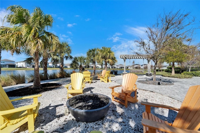 view of property's community with a water view, a patio, a fire pit, and a pergola