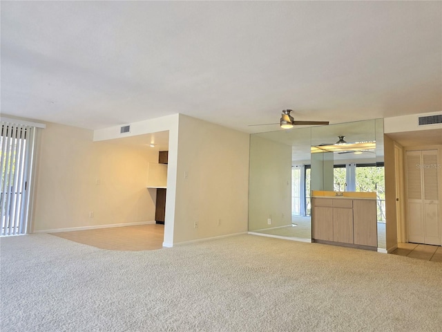 carpeted empty room featuring ceiling fan and sink