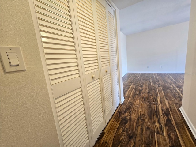 corridor with dark hardwood / wood-style flooring