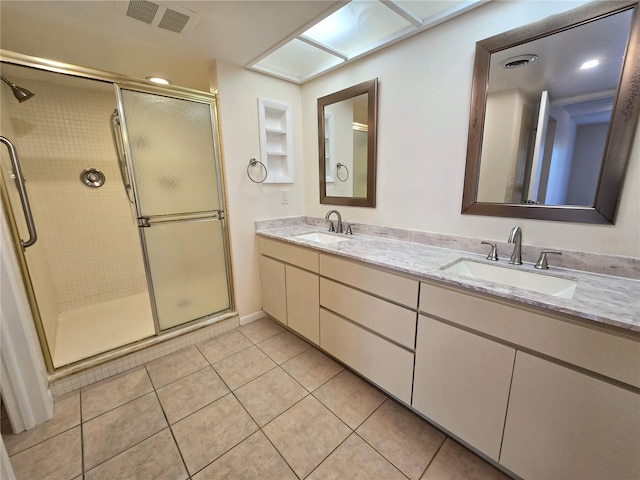 bathroom with tile patterned floors, a shower with door, and vanity