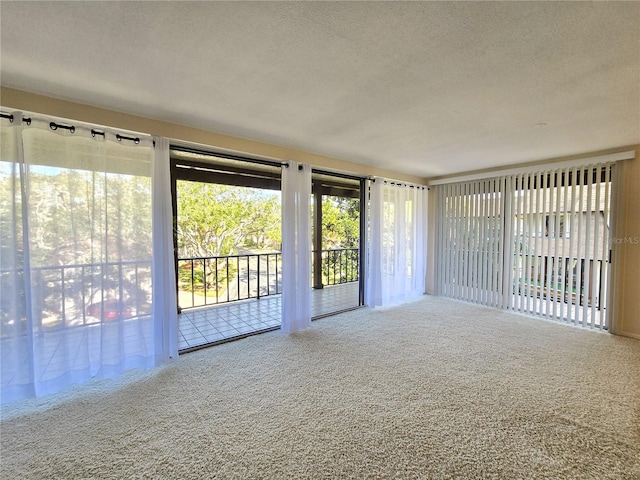 unfurnished living room with carpet flooring and a textured ceiling