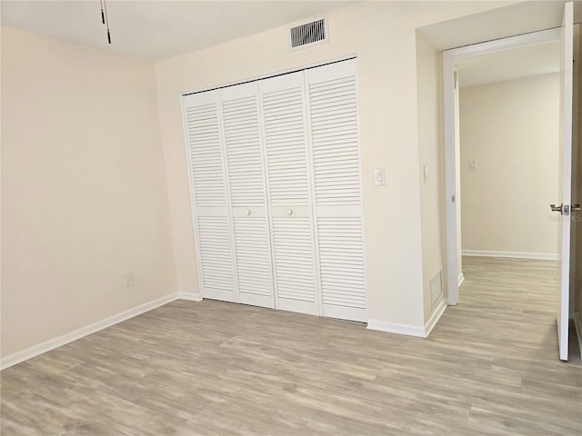 3031 Countryside Blvd Unit 35C, Clearwater, FL 33761 - unfurnished bedroom featuring light wood-style flooring, a closet, and baseboards