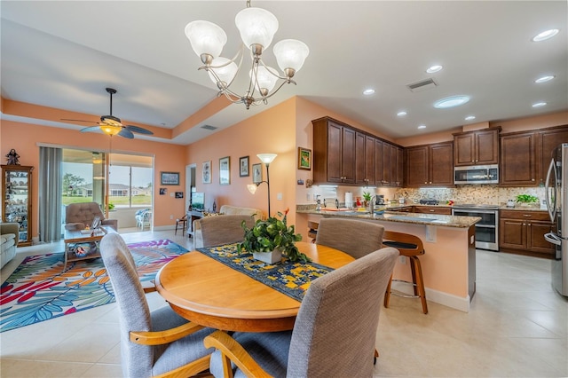 dining room with ceiling fan with notable chandelier