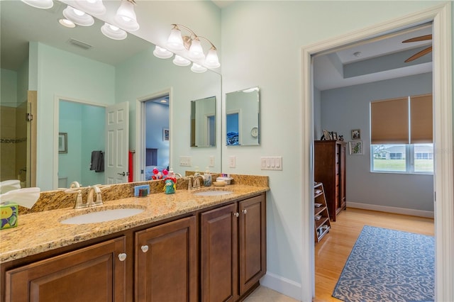 bathroom with ceiling fan, wood-type flooring, a shower with door, and vanity