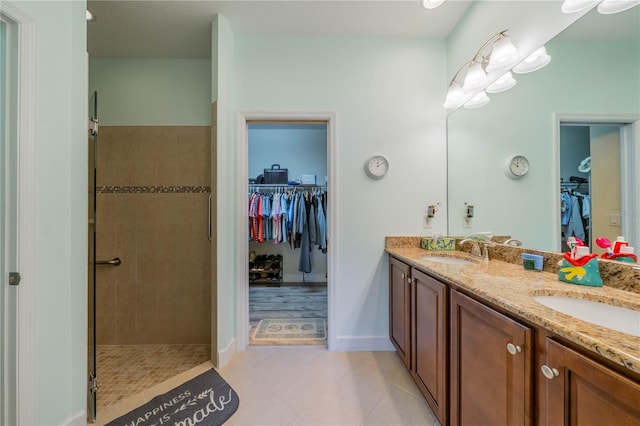 bathroom featuring tile patterned floors, vanity, and tiled shower