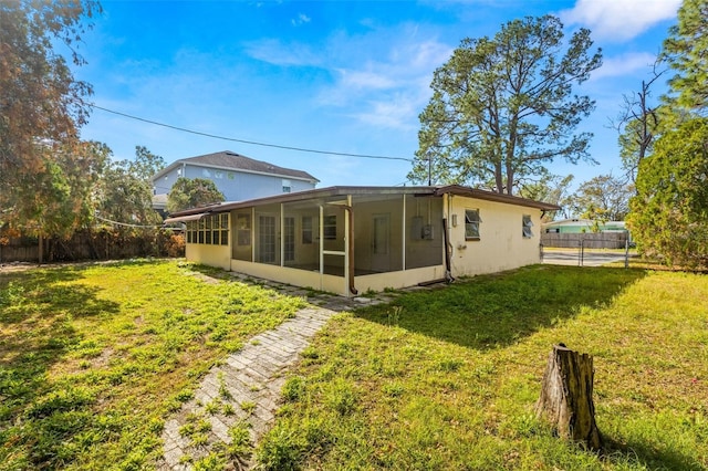 back of property featuring a lawn and a sunroom