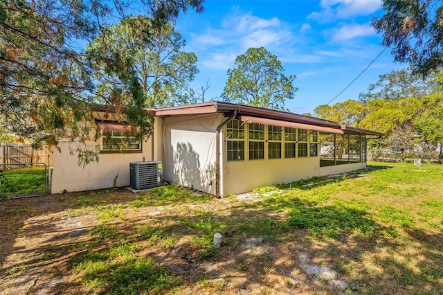 back of property with a yard and central air condition unit