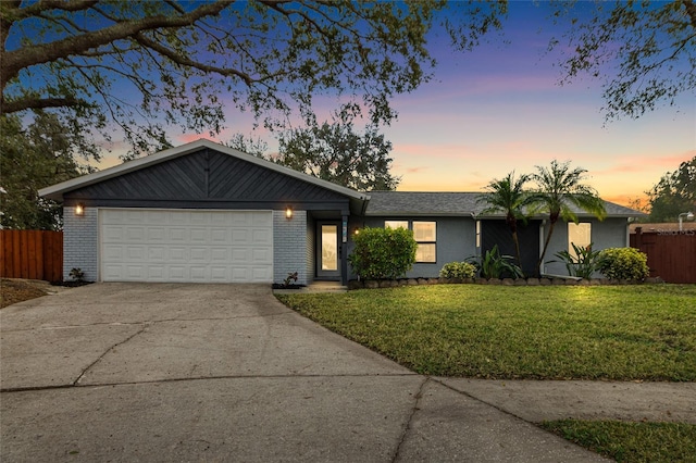 ranch-style home with a garage and a yard