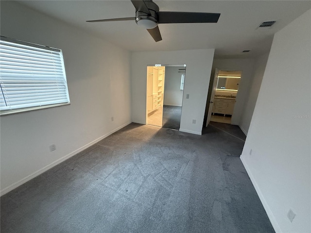 unfurnished bedroom with carpet, visible vents, ceiling fan, ensuite bath, and baseboards