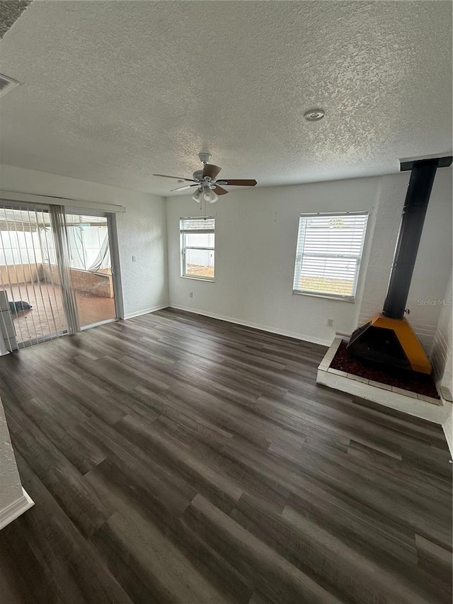 spare room featuring dark wood-type flooring, ceiling fan, a textured ceiling, and baseboards