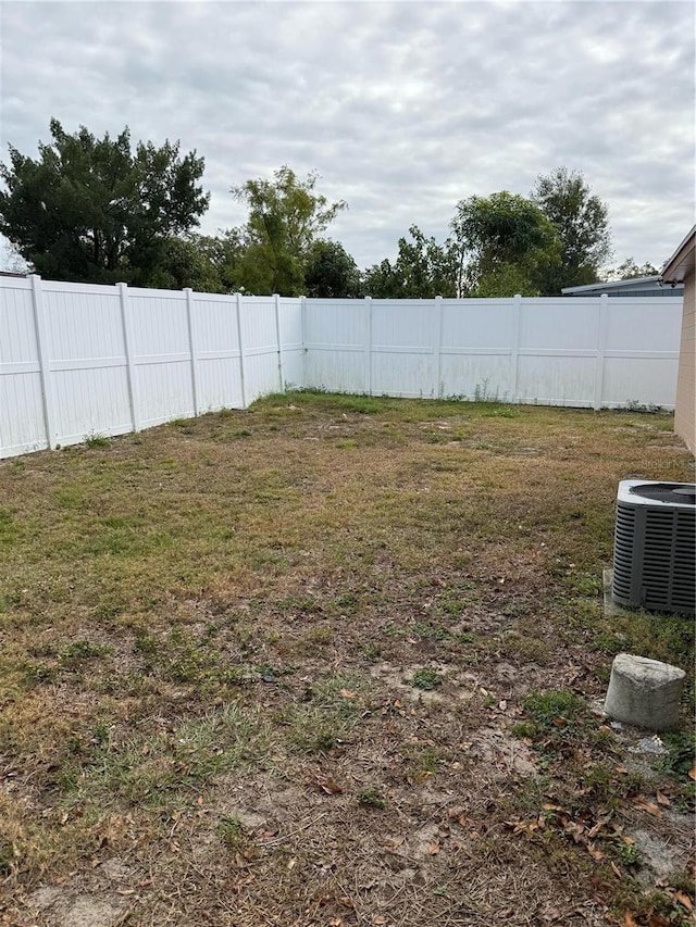 view of yard featuring central air condition unit and fence