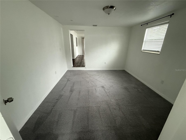 carpeted empty room with baseboards