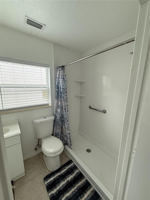 full bath featuring a textured ceiling, vanity, visible vents, tile patterned floors, and a stall shower