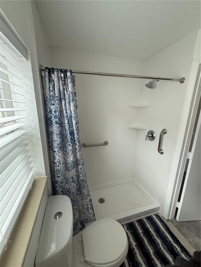 bathroom with a stall shower and toilet