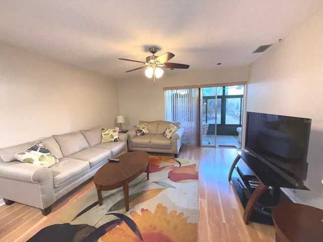 living room featuring light wood-type flooring and ceiling fan