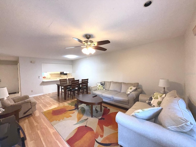 living room with ceiling fan and light wood-type flooring