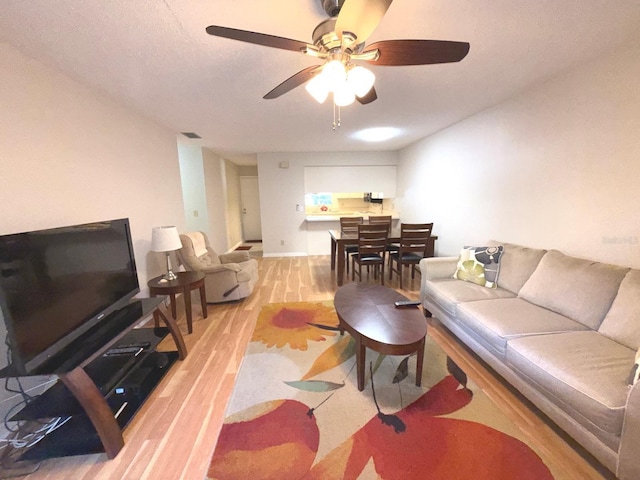 living room with light wood-type flooring and ceiling fan