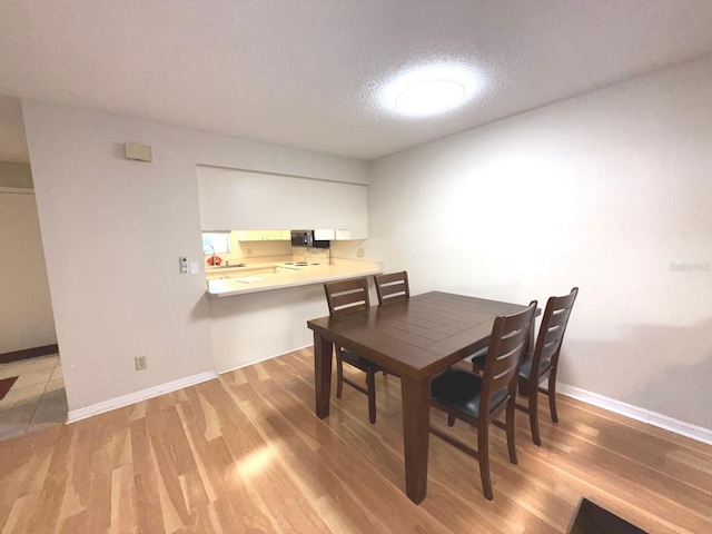 dining area with a textured ceiling and hardwood / wood-style flooring