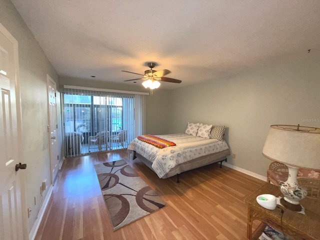 bedroom featuring access to outside, ceiling fan, wood-type flooring, and a textured ceiling