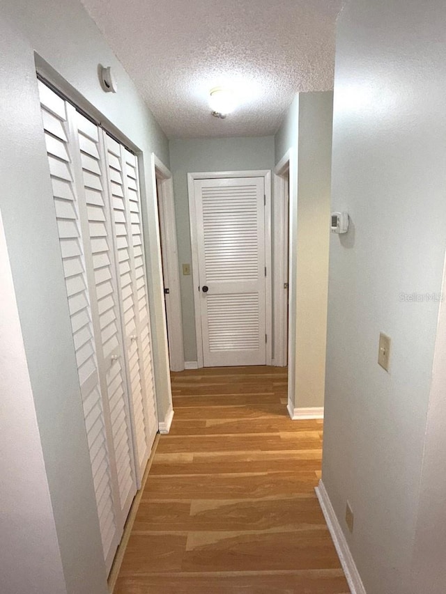 corridor featuring hardwood / wood-style floors and a textured ceiling