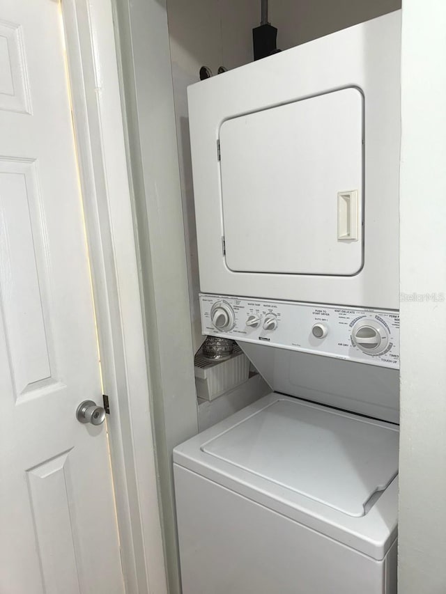 clothes washing area featuring stacked washer and dryer