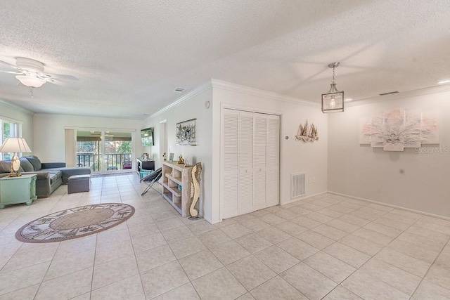 living room featuring crown molding, light tile patterned floors, a textured ceiling, and ceiling fan