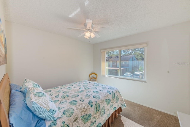 carpeted bedroom with ceiling fan and a textured ceiling