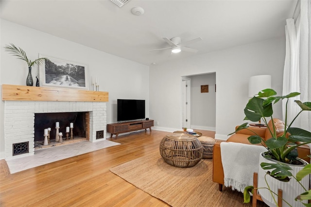 living room featuring a fireplace, hardwood / wood-style floors, and ceiling fan