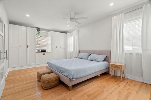 bedroom featuring multiple windows, light wood-type flooring, and ceiling fan