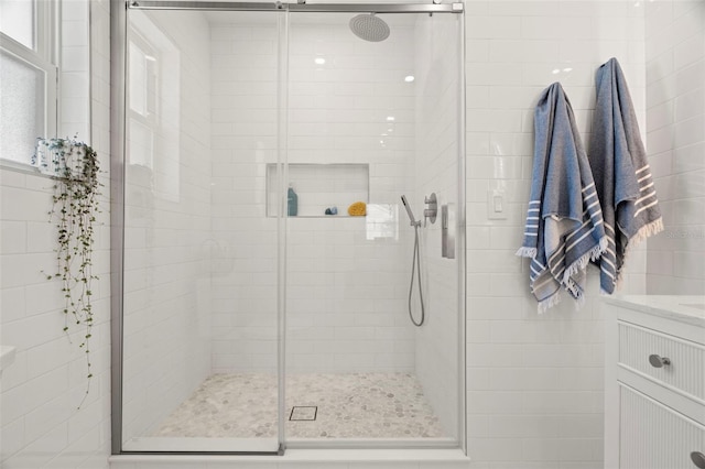 bathroom with vanity and a shower with door