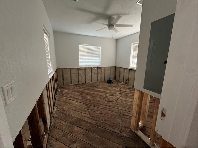 empty room with electric panel, ceiling fan, and dark hardwood / wood-style floors