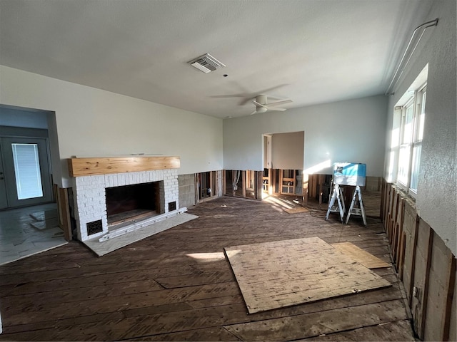 unfurnished living room featuring ceiling fan, a fireplace, and dark hardwood / wood-style floors