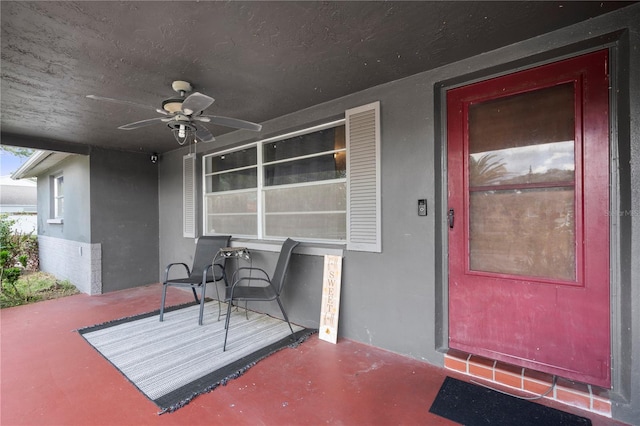 doorway to property featuring a porch and ceiling fan