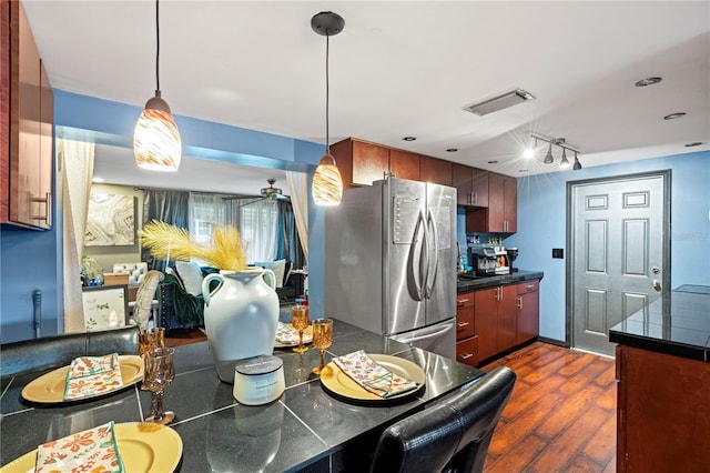 kitchen with dark hardwood / wood-style floors, stainless steel fridge, hanging light fixtures, and ceiling fan