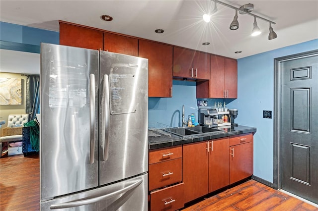 kitchen with stainless steel fridge, dark hardwood / wood-style flooring, sink, and track lighting