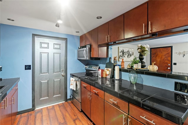 kitchen with light wood-type flooring and appliances with stainless steel finishes