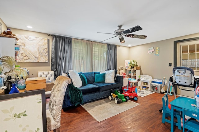 living room featuring ceiling fan and dark wood-type flooring