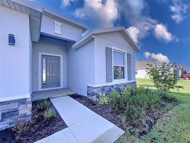 entrance to property featuring a yard