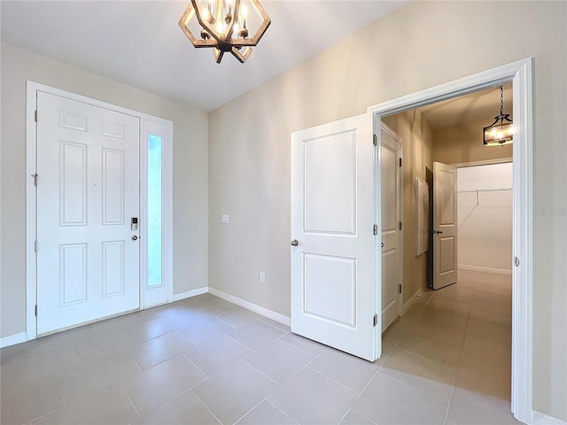 tiled entryway with a chandelier