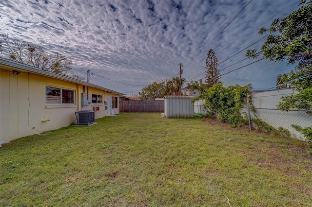 view of yard with central AC and a storage unit