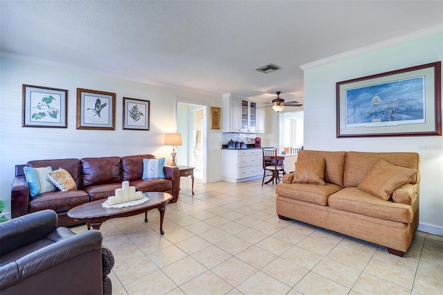 tiled living room featuring a textured ceiling, ceiling fan, and crown molding